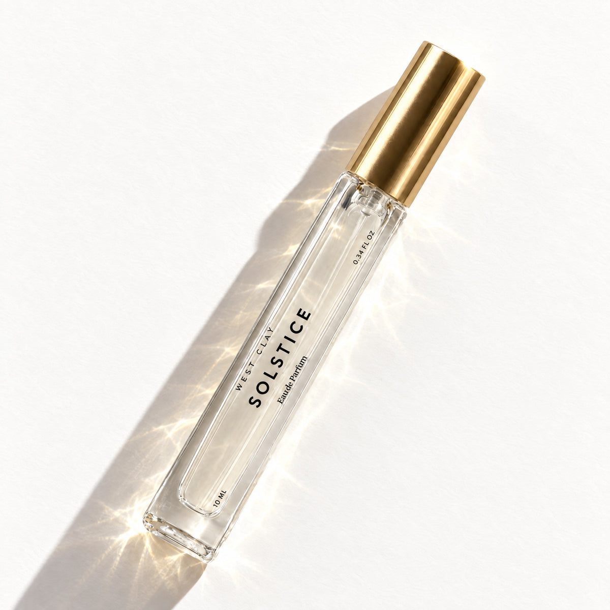 Solstice Eau de Parfum by West Clay, 10 mL travel size flash flat lay studio photo