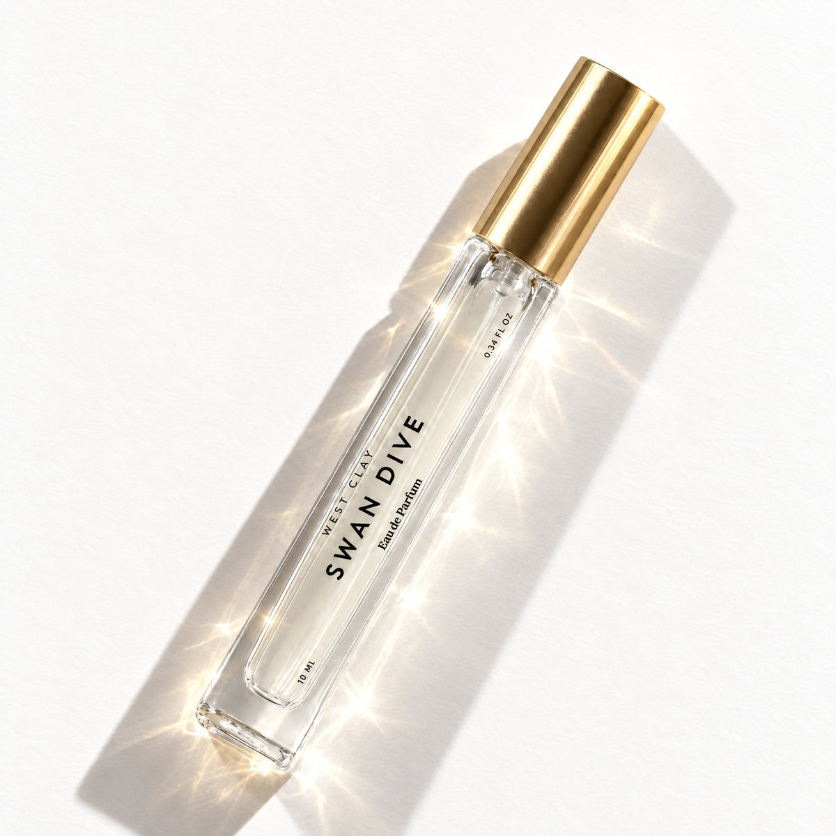 Swan Dive Eau de Parfum by West Clay, 10 mL travel size flash flat lay studio photo